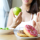 Woman rejecting junk food or unhealthy food such as donuts and c
